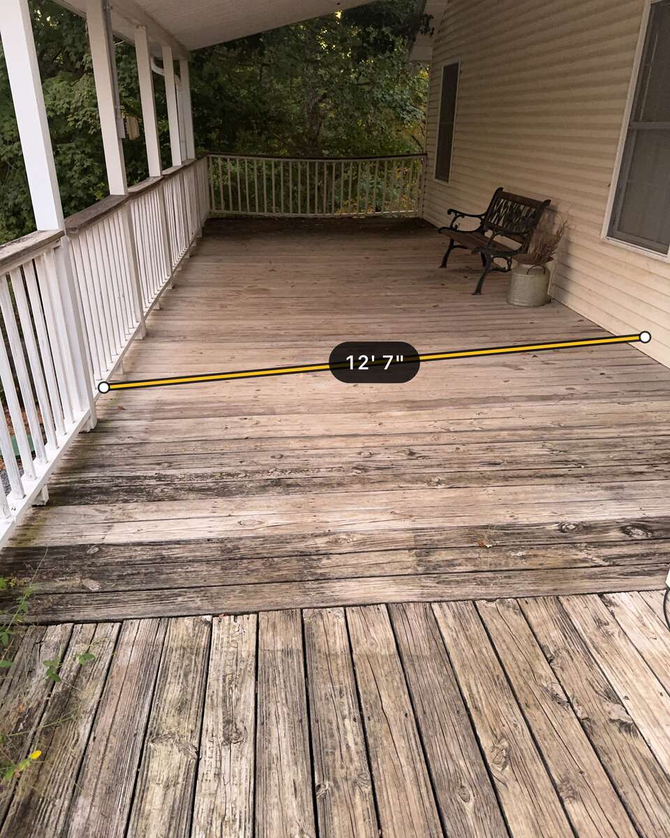A covered porch deck photographed in Measure mode, with an amber line drawn across the deck and the reading 12′ 7″.